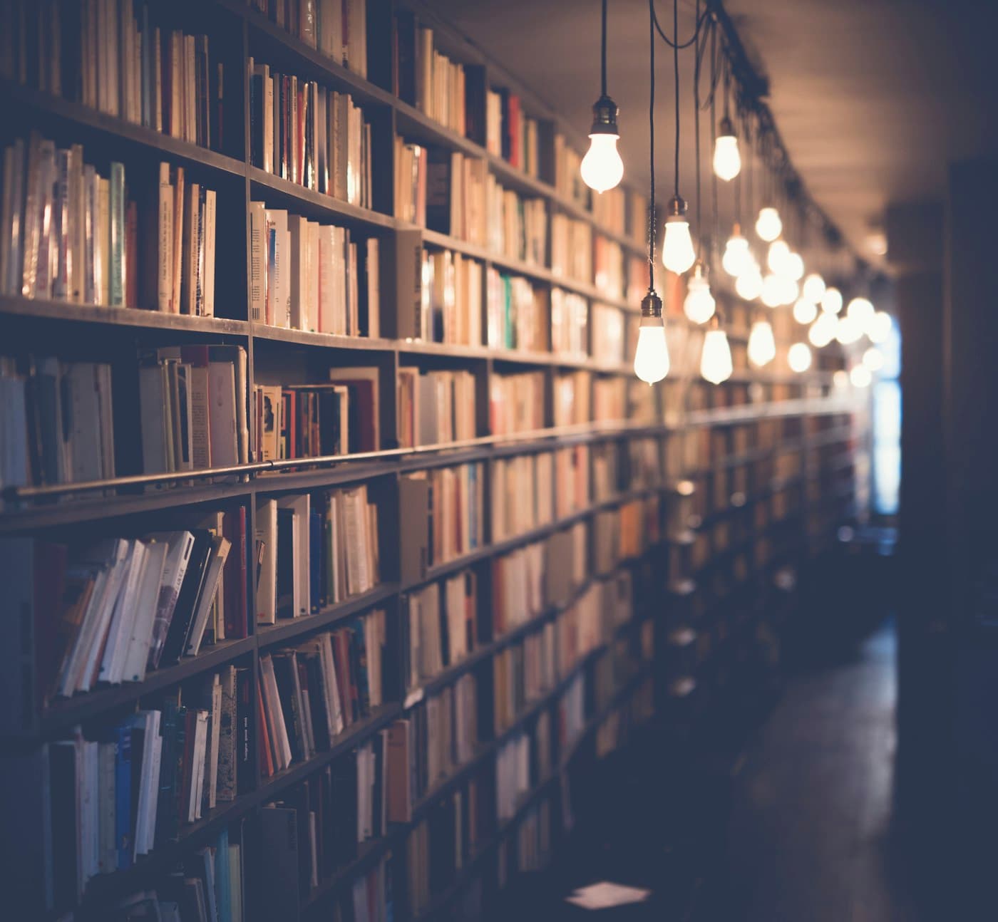 Stack of books on a wooden table beside a coffee mug