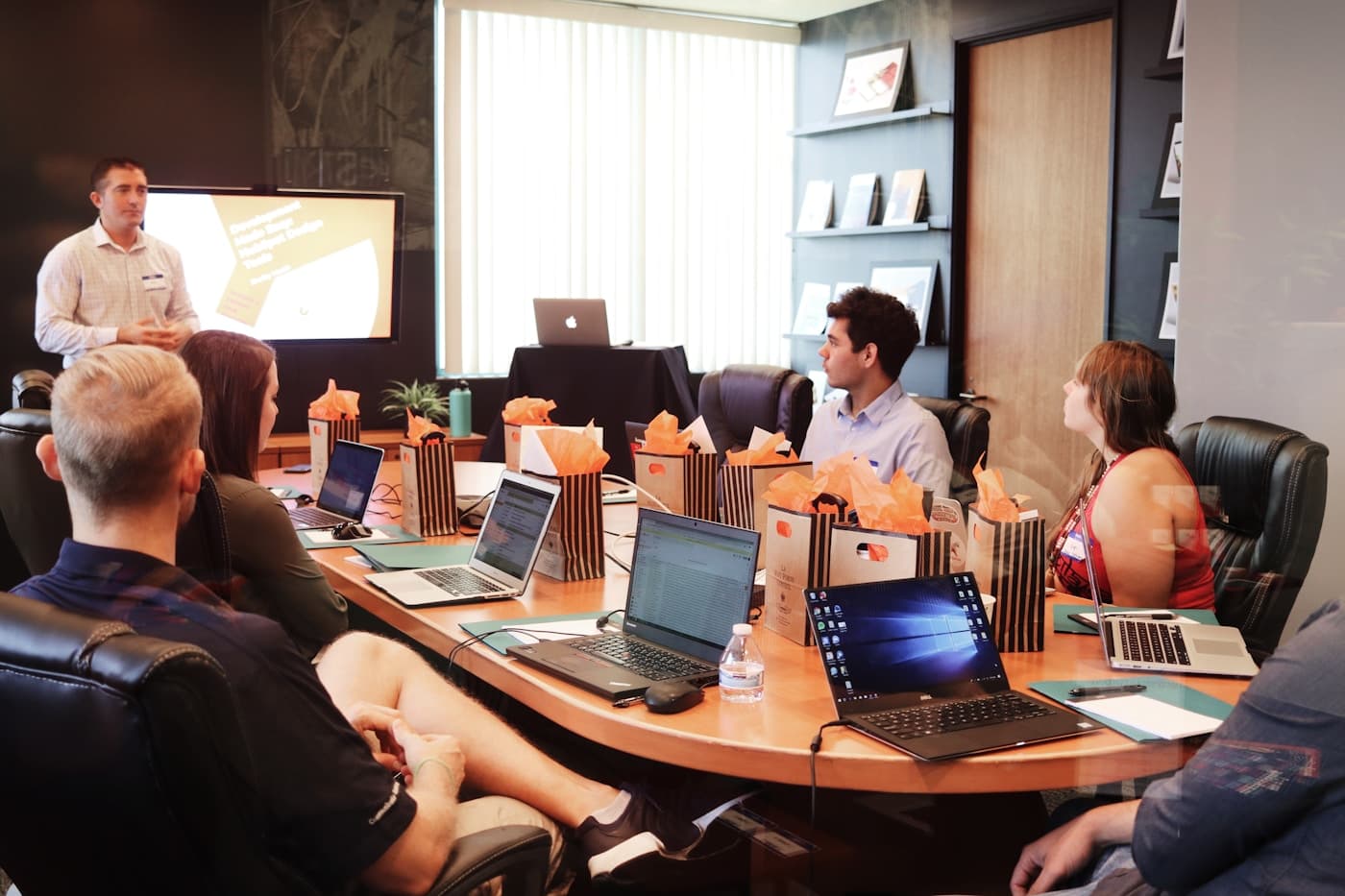 Colleagues reviewing charts and notes together at a conference table with laptops