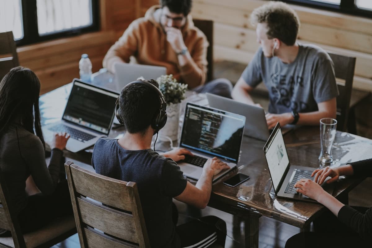 Colleagues collaborating around a laptop in an office