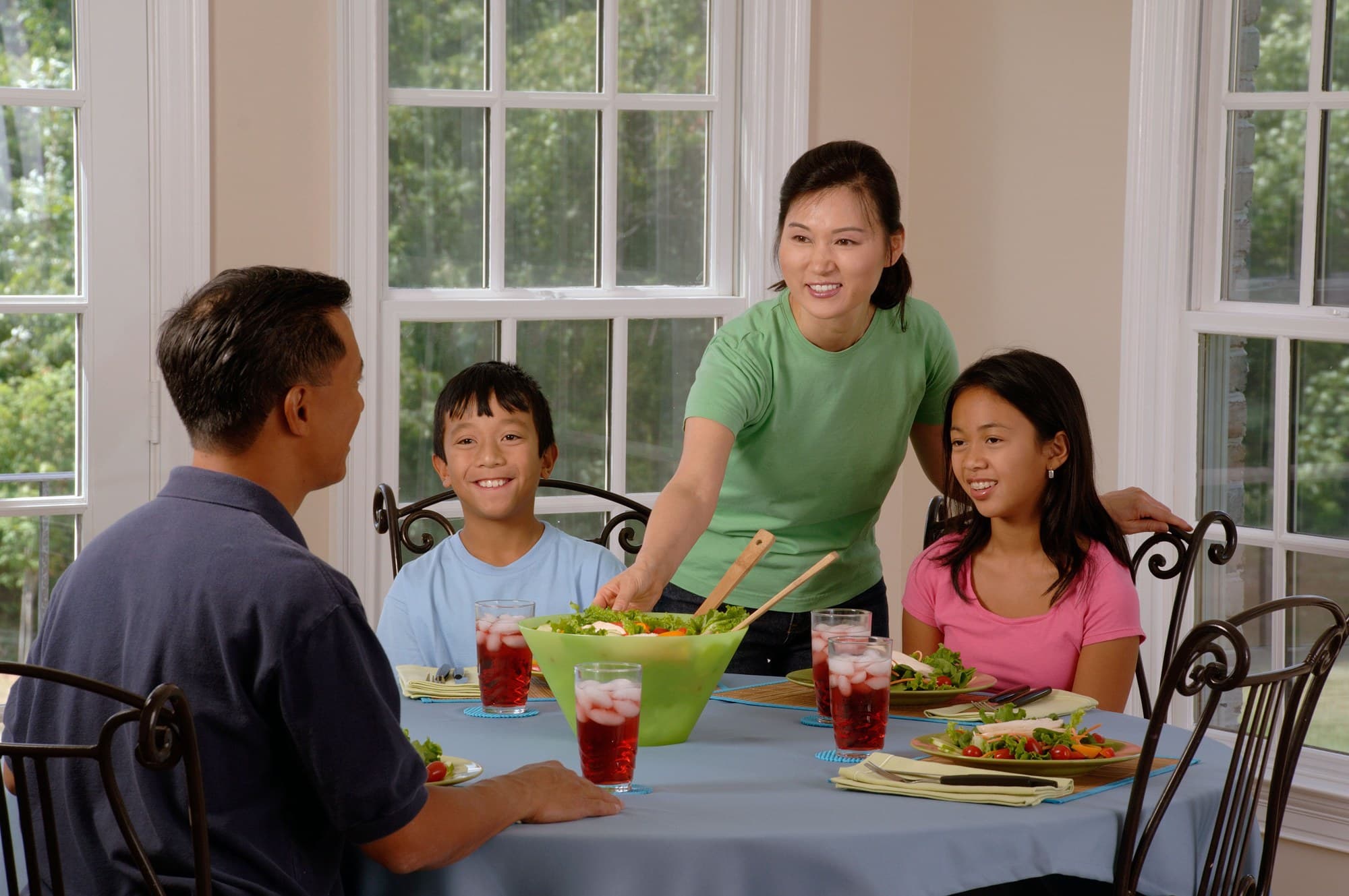 An Asian American family sharing a meal at a sunlit dining table
