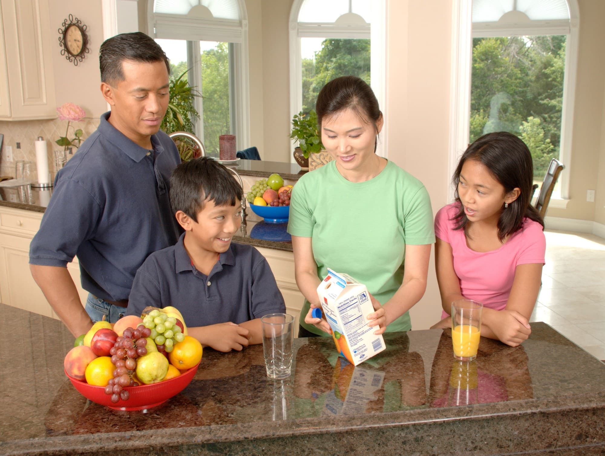An Asian American family gathered around a kitchen island at home