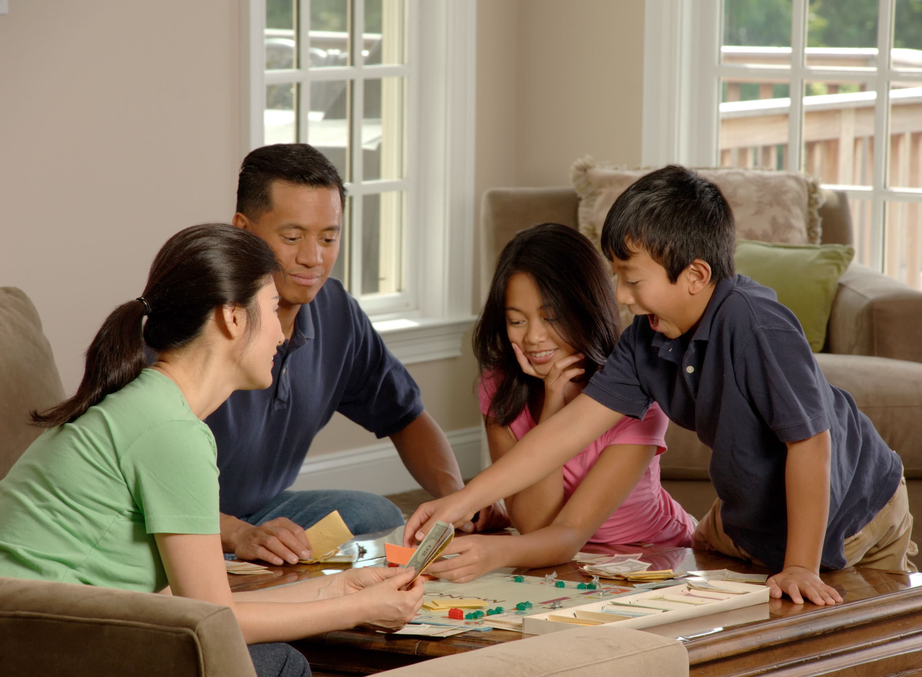 An Asian American family gathered around a living-room table at home