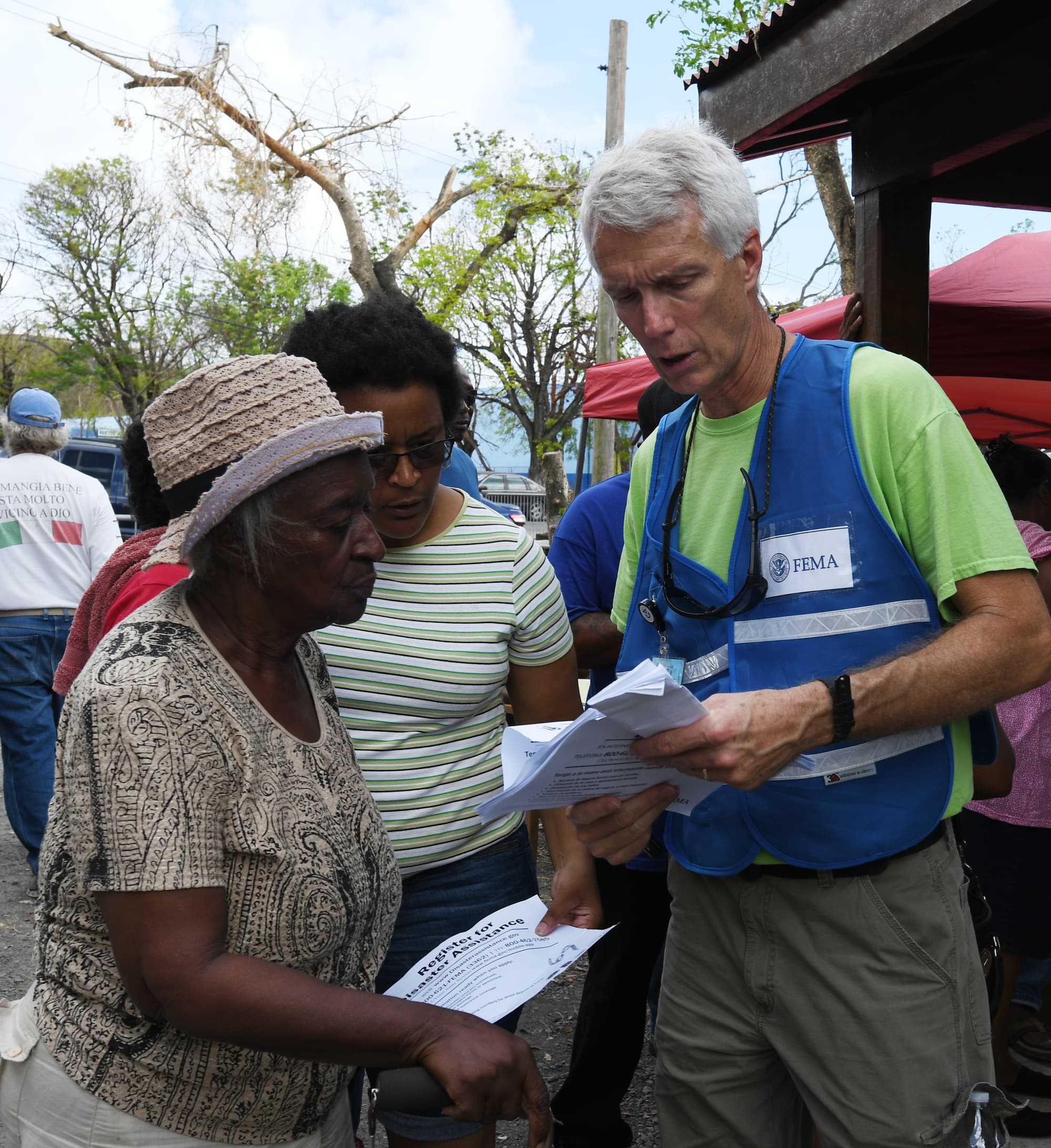 A mother and adult daughter speak with a FEMA worker while completing disaster assistance registration