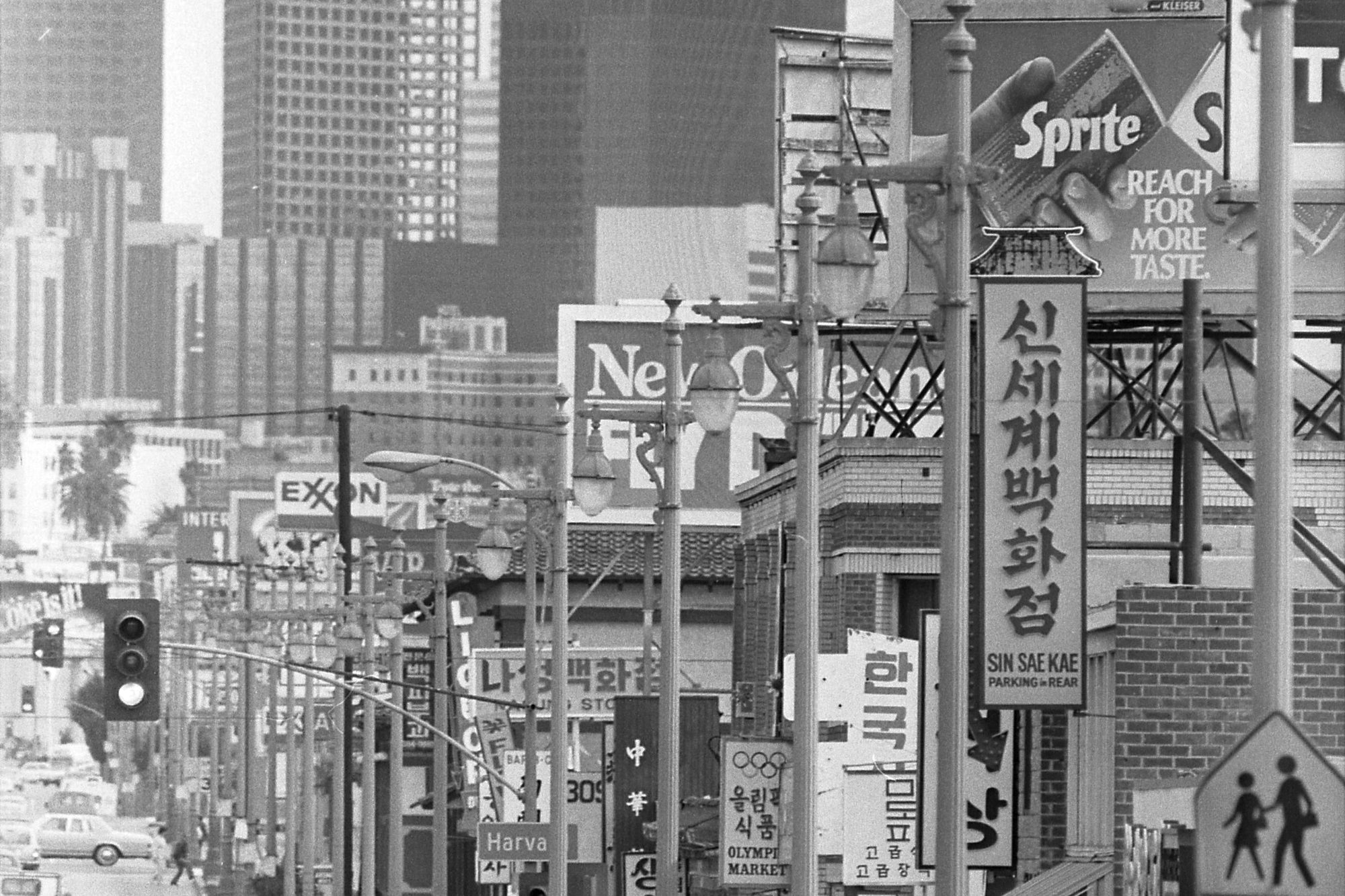 Korean-language shop signs along Olympic Boulevard in Los Angeles Koreatown, with downtown towers in the distance