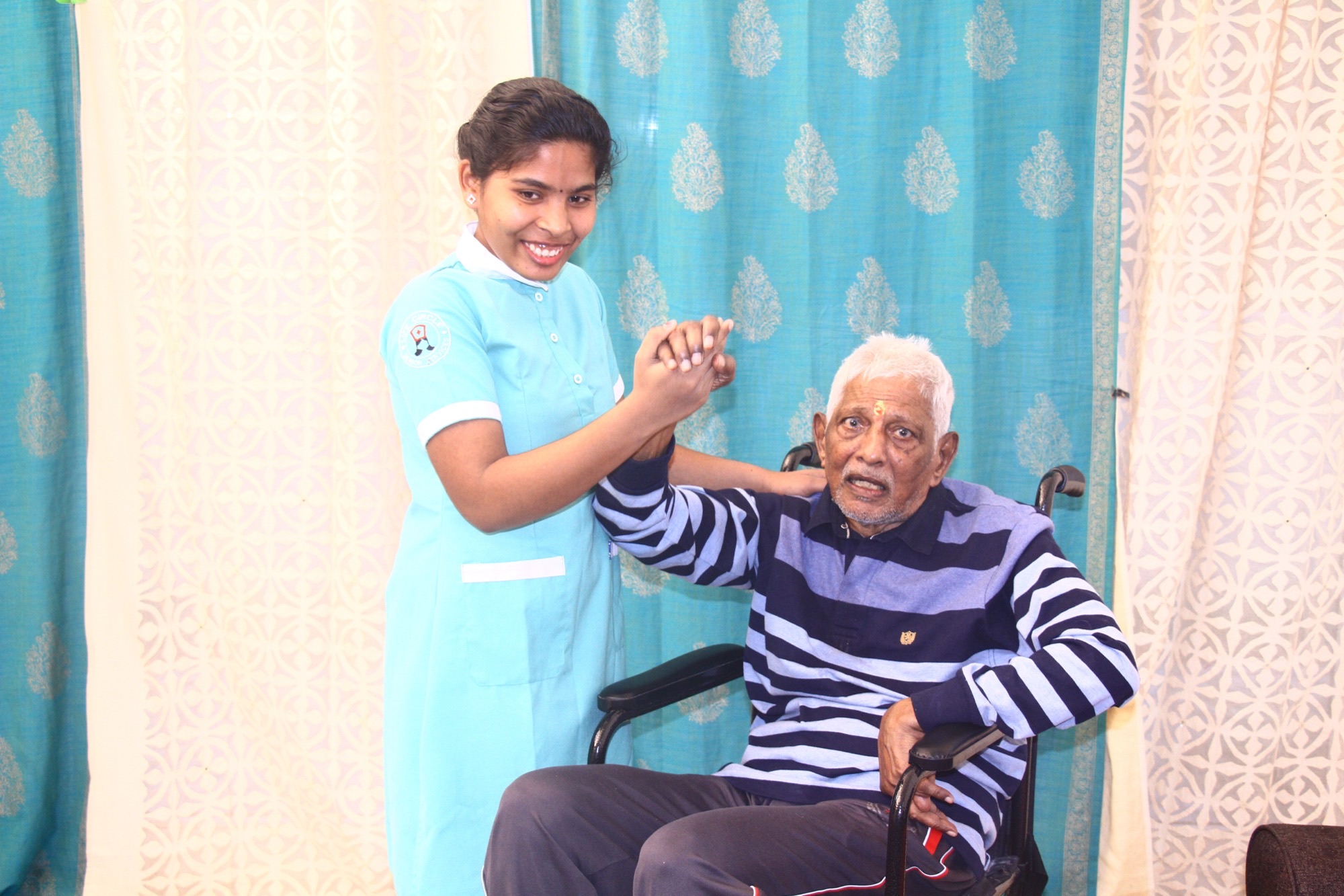 Home care worker assisting an older adult in a wheelchair