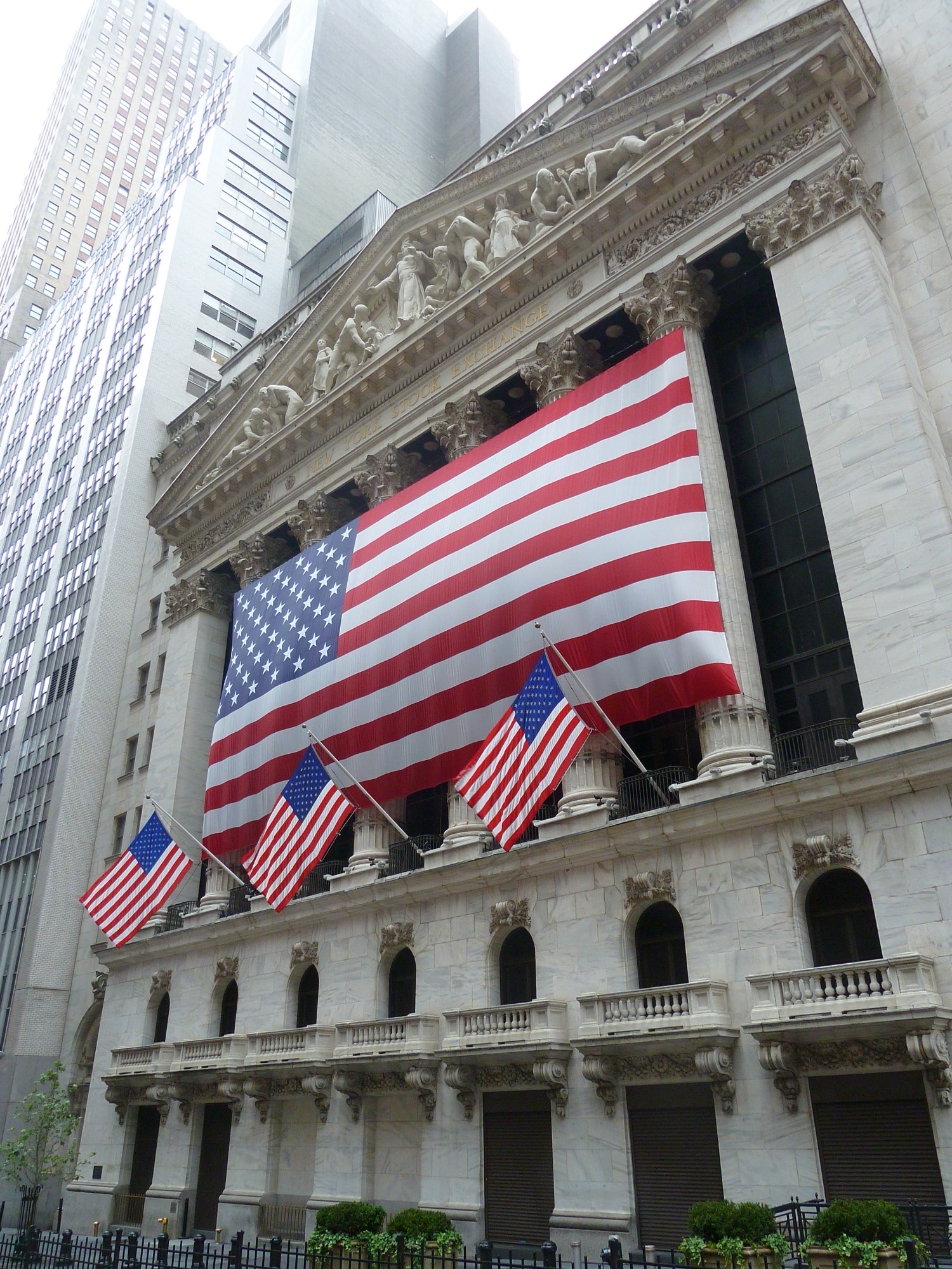 Facade of the New York Stock Exchange with Corinthian columns and American flags